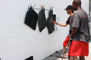 Shop manager Allen West sprays the Mazda floormats to kill the mold and mildew